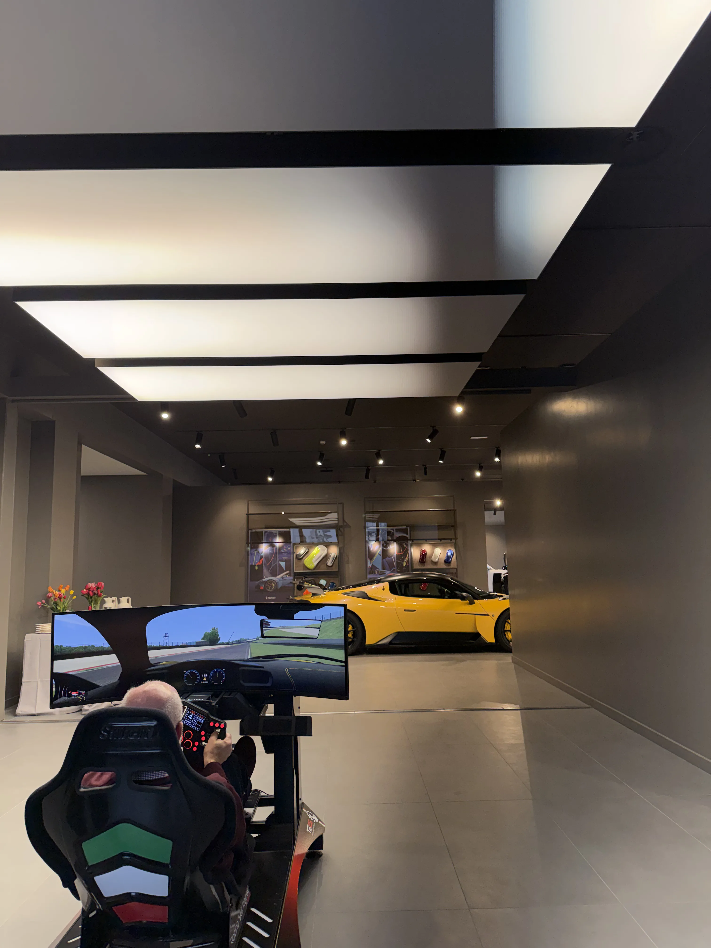 Simulatore professionale nella sede Technosim25 accanto a un'auto sportiva